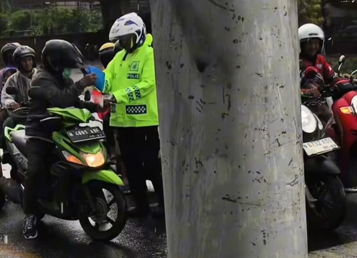 Haru! Polantas Polres Malang Bagikan Jas Hujan ke Pengendara di Tengah Hujan Deras