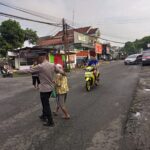 Kapolsek Donomulyo Turun Langsung Pantau Arus Lalu Lintas dan Bantu Warga Menyeberang Jalan